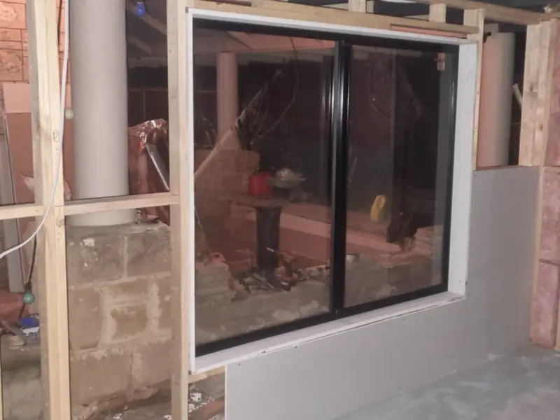 Timber framing around new window and door openings, with insulation in the wall