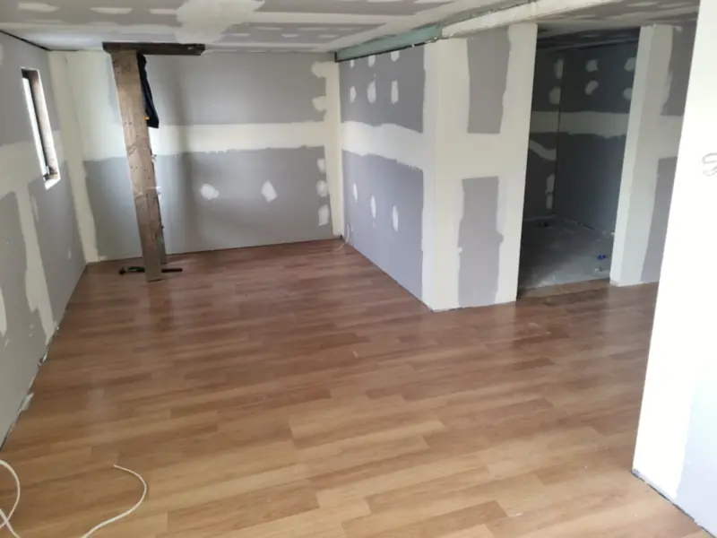 Plasterboard joints set across a room with a new timber-look laminate floor laid