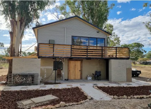 Two-storey home exterior with new cladding, balcony and landscaping