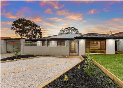 Renovated home street frontage at dusk with landscaped garden and driveway